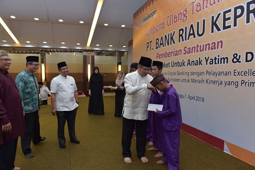 Sempena HUT 52 Bank Riau Kepri Berikan Santunan Kepada 1115 Anak Yatim Direktur Utama Bank Riau Kepri DR. Irvandi Gustari menyerahkan langsung santunan secara simbolis kepada salah satu anak yatim dari 1115 orang Anak Yatim