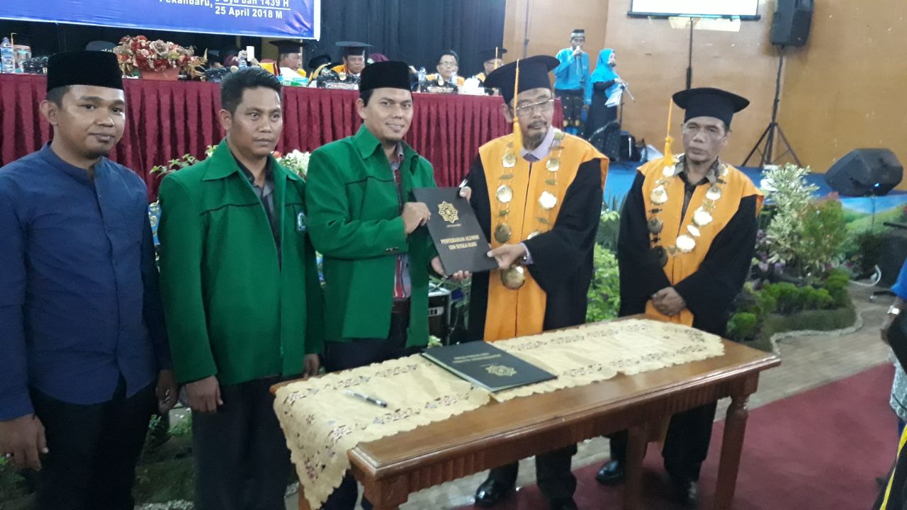 Foto Rektor UIN Suska Riau Prof Dr H Munzir Hitami, MA menyerahkan alumni wisuda program doktor, magister, sarjana dan diploma kepada Sekum PP IKA UIN Khairuddin Al-Young Riau 