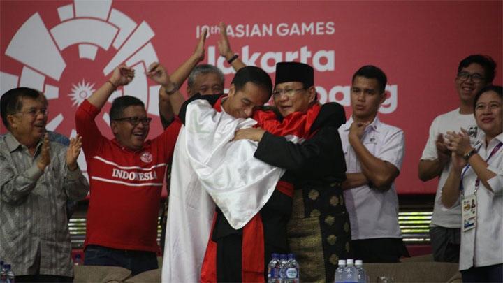 Jokowi dan Prabowo dipeluk atlet silat Asian Games sembari diselimuti bendera Merah Putih Sumber Gambar : Tempo.co
