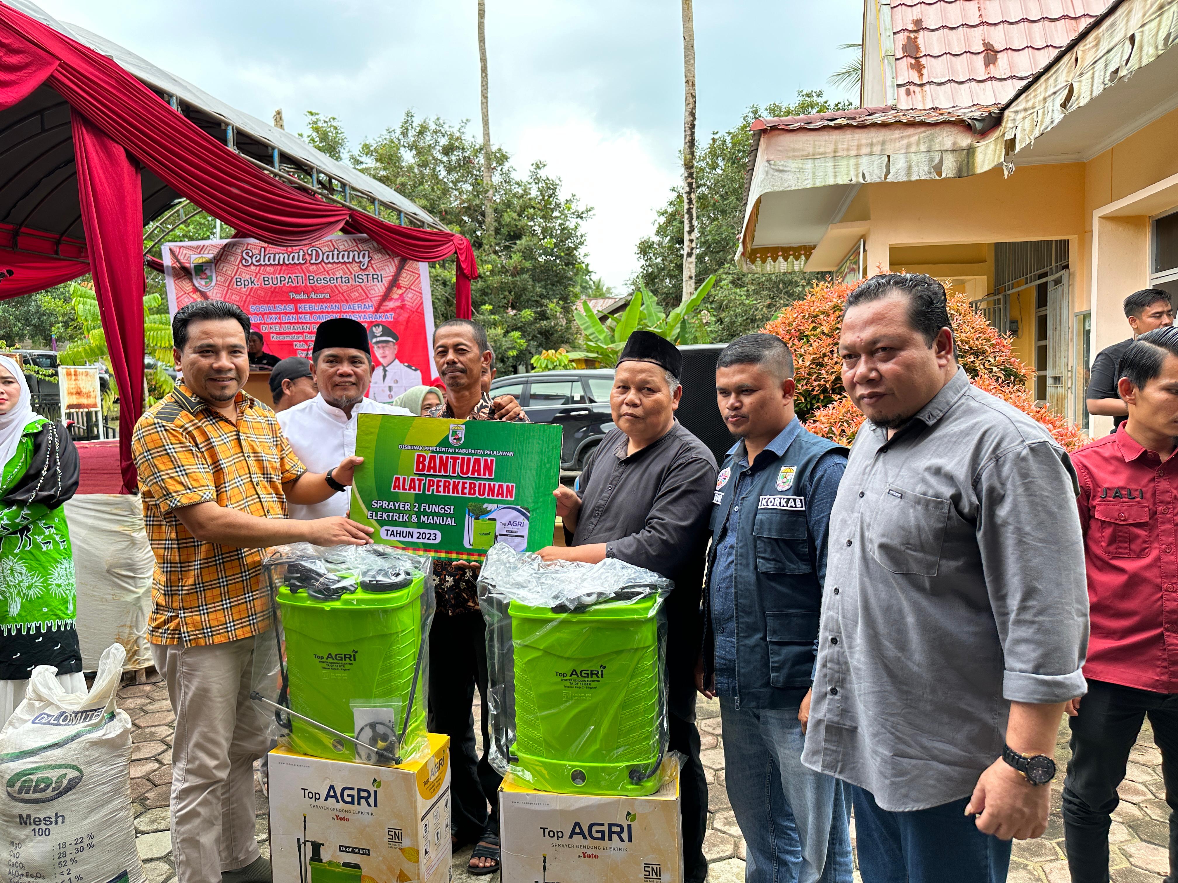 Bupati Pelalawan H. Zukri SE didampingi anggota DPRD Kabupaten Pelalawan Nasaruddin Arnash SH. MH dan Nasarudin SH.MH tampak serahkan bantuan kepada masyarakat.