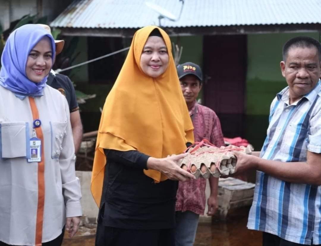 Peninjauan Sekaligus Pemberian Bantuan Kepada Korban Banjir Bersama Pj Ketua TP PKK Kabupaten Kampar Pj Ketua Tim Penggerak PKK Kabupaten Kampar Ricana Djayanti Hambali terlihat memberikan bantuan berupa sembako kepada korban banjir.