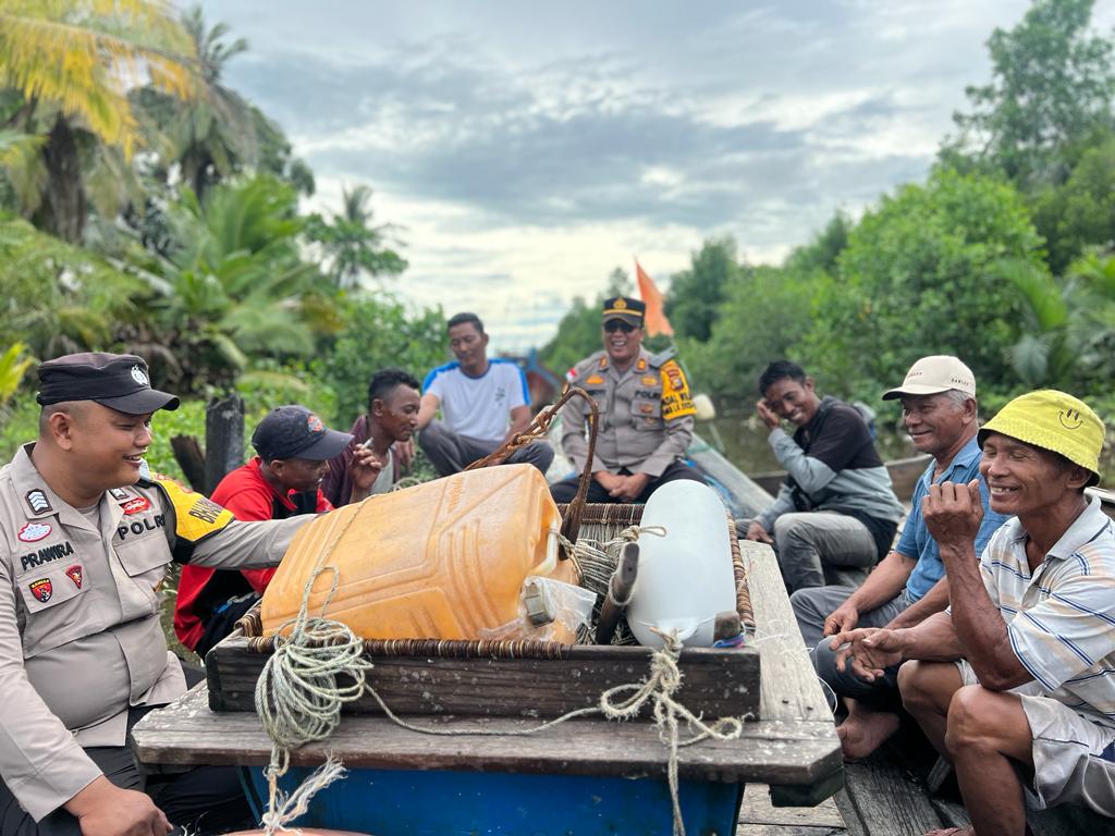 Butuh waktu 2 Jam, Kapolsek Rupat Temui Nelayan Pulau Terluar Sampaikan Pesan Pemilu Damai Terlihat Kapolsek Rupat sedang berbincang-bincang dengan para nelayan di kapal.